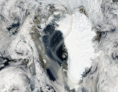 Kouř z rozsáhlých požárů na západě Kanady nad Grónskem a Arktidou. Fotografie družice Aqua ze 17. srpna 2023.  Kanadu postihly nejhorší požáry v historii celé Severní Ameriky. Do 17. srpna plameny spálily více než 13,7 milionů hektarů lesních porostů, což je sedminásobek dlouhodobého průměru (za posledních 25 let).